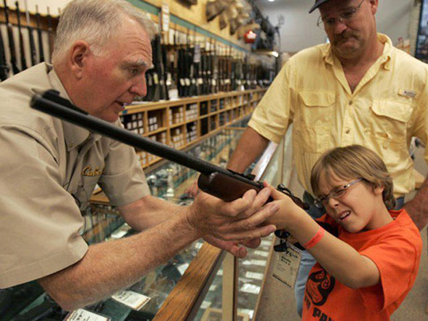 hunter mcconathy c 7 holds a hunting rifle with a short stock as his father bryan r and cabela 039 s salesman russ duncan l watch him at the cabela 039 s store in fort worth texas photo reuters