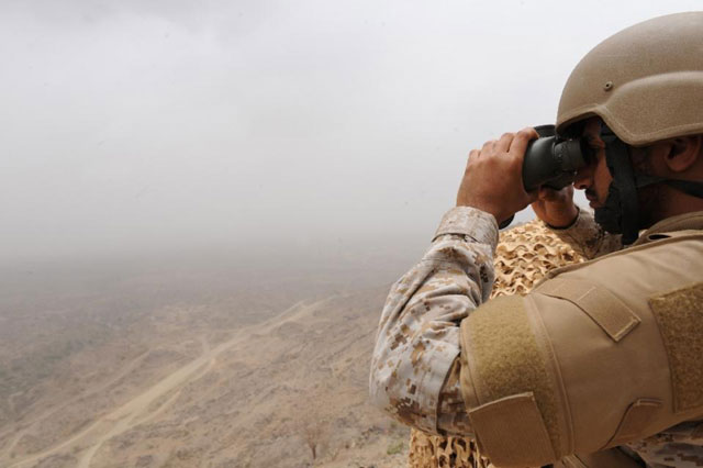 a saudi soldier looks through binoculars from a position at al dokhan mountain on the saudi yemeni border in southwestern saudi arabia on april 13 2015 photo afp