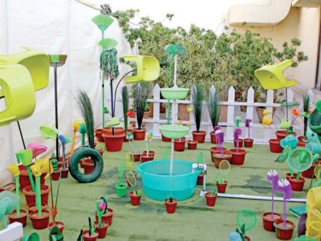 an art installation shows a garden made of plastic utensils toilet brushes and discarded shoes an art installation shows a garden made of plastic utensils toilet brushes and discarded shoes