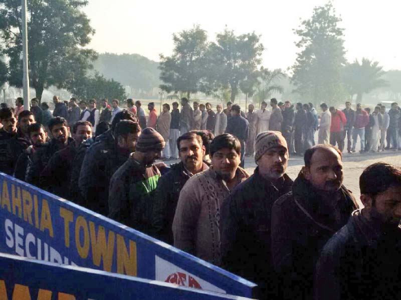 people wait in queue outside a bahria town office photo express