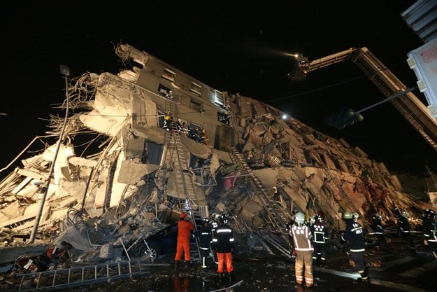 rescuers are seen entering an office building that collapsed on its side from an early morning earthquake in tainan southern taiwan on feb 6 2016 photo afp