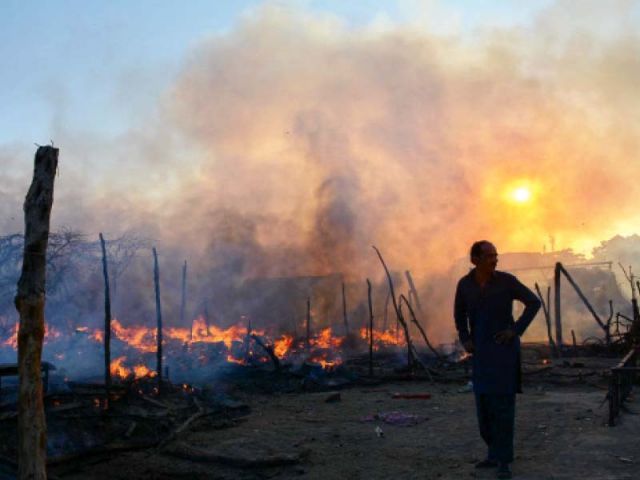 in this file photo a man surveys the damage caused by the blaze that destroyed a dozen shanties in karachi photo mohammad noman express