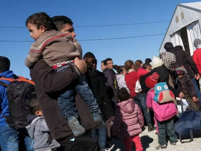 a migrant carries a child as refugees and migrants wait for a train to continue their journey towards western europe from the macedonia greece border at the vinojug temporary transit centre outside the village of gevgelija macedonia february 1 2016 photo reuters a migrant carries a child as refugees and migrants wait for a train to continue their journey towards western europe from the macedonia greece border at the vinojug temporary transit centre outside the village of gevgelija macedonia february 1 2016 photo reuters