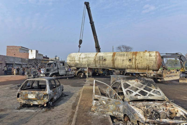 a crane lifts wreckage of a burnt lpg tanker that collided with a car in the district of sheikhupura on wednesday photo afp a crane lifts wreckage of a burnt lpg tanker that collided with a car in the district of sheikhupura on wednesday photo afp