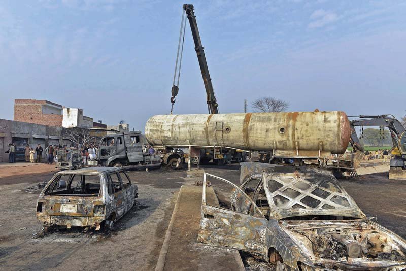 a crane lifts wreckage of a burnt lpg tanker that collided with a car in the district of sheikhupura on wednesday photo afp