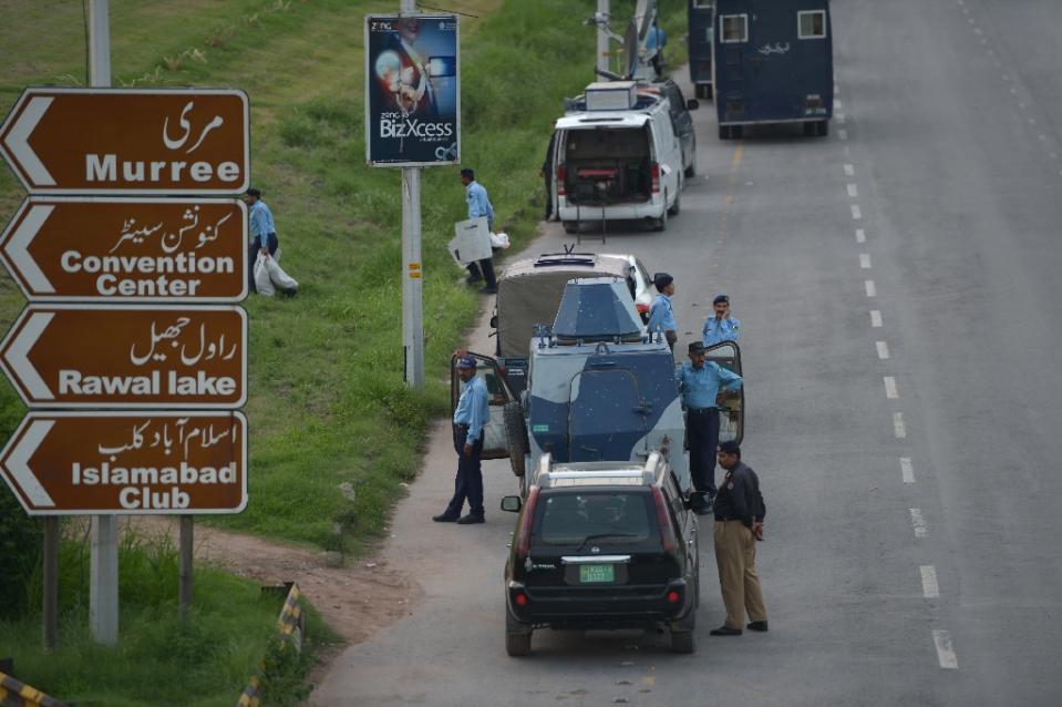 pakistani policemen stand next to their vehicles in islamabad on august 9 2014 photo afp