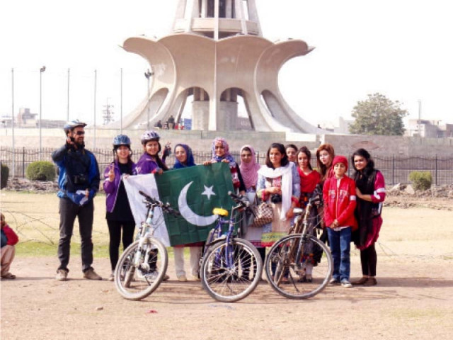 the cyclists pose with fans in front of minar e pakistan photo express the cyclists pose with fans in front of minar e pakistan photo express