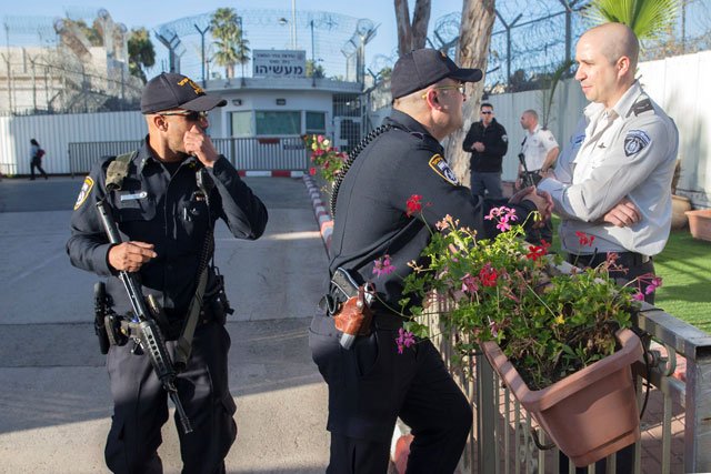 israeli police officers talk before israeli prime minister ehud olmert arrives at the maasiyahu prison in the central israeli city of ramle on february 15 2016 to begins a 19 month term for bribery and obstruction of justice photo afp