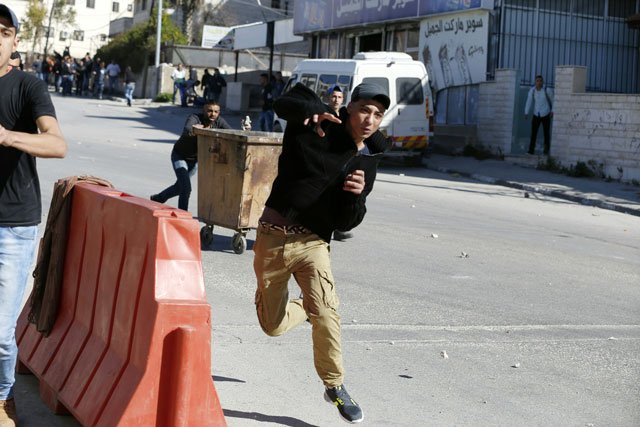 a palestinian young man throws stones on february 15 2016 at the amari palestinian refugee camp near the west bank city of ramallah during clashes with israeli soldiers that erupted after they entered the camp early in the morning photo afp