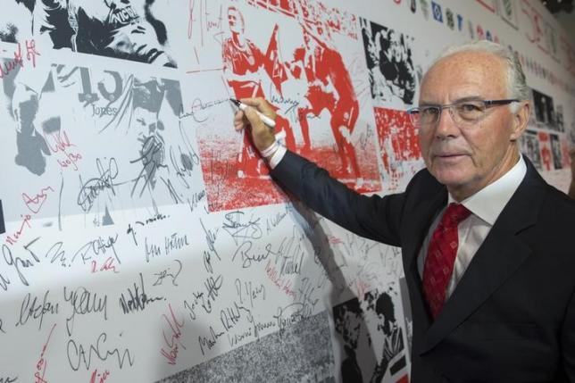 former player and coach franz beckenbauer signs a wall of fame at a gala marking the 50th anniversary of the foundation of the german bundesliga soccer league in berlin august 6 2013 photo reuters