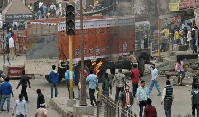 protestors gather near a burning truck during violent clashes with rival caste groups in rohtak on february 19 2016 photo afp protestors gather near a burning truck during violent clashes with rival caste groups in rohtak on february 19 2016 photo afp