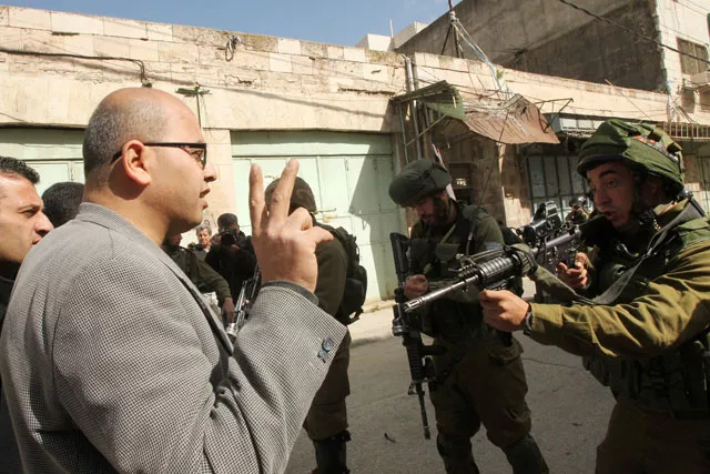 an israeli soldier aims his weapon at a palestinian protester flashing the sign of victory during clashes following a demonstration against jewish settlements and the closing of al shuhada street on february 20 2016 in the west bank city of hebron photo afp an israeli soldier aims his weapon at a palestinian protester flashing the sign of victory during clashes following a demonstration against jewish settlements and the closing of al shuhada street on february 20 2016 in the west bank city of hebron photo afp