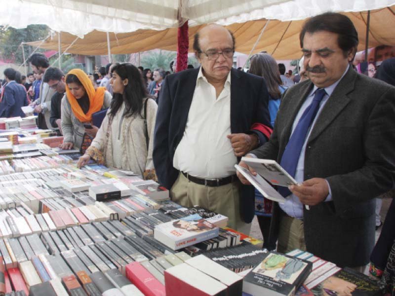 safma chairman imtiaz alam catches a glimpse of a book held by another visitor photo abid nawaz express