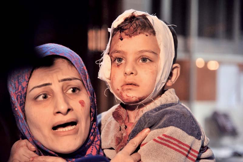 a distraught syrian woman holds her injured child close at a hospital after a bombing in damascus photo afp