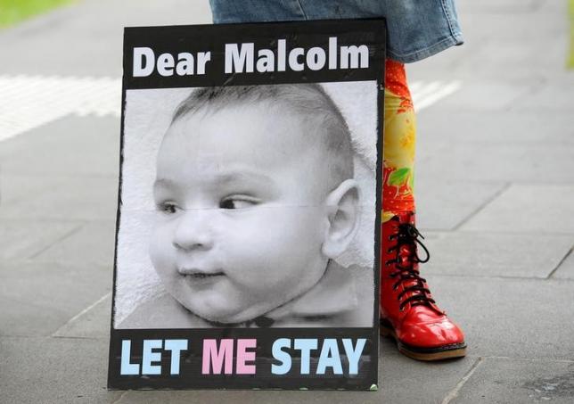 a banner calling for australian prime minister malcolm turnbull to allow the infant children of asylum seekers to remain in australia and not in offshore detention centers is shown during a demonstration in melbourne australia february 19 2016 photo reuters