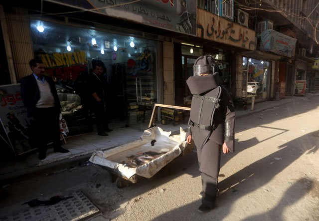 an iraqi youth dressed in a mock bomb suit designed by iraqi artist hussein adil walks during a public performance in the streets of the capital baghdad on february 10 2016 photo afp