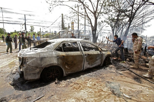 thai bomb squad unit officers inspect a burnt out car after a bomb blast took place in thailand 039 s restive southern province of pattani on february 27 2016 photo afp