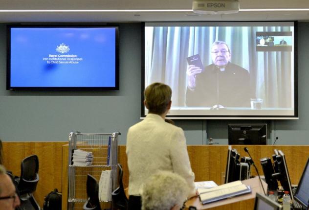 senior counsel assisting gail furness stands in front of a screen displaying australian cardinal george pell as he holds a bible while appearing via video link from a hotel in rome italy to testify at the australia 039 s royal commission photo reuters