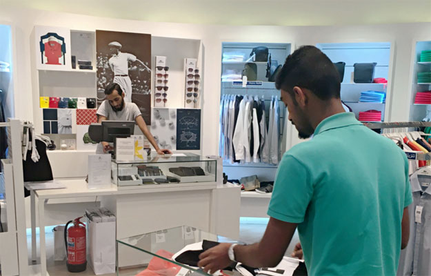 abdullah al awaji folds clothes at a lacoste outlet in a mall in riyadh while his saudi colleague works a cash register in february 2016 photo washington post