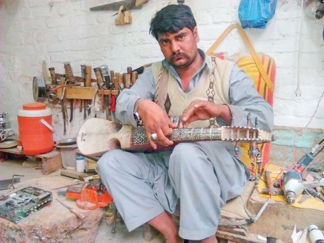 khursheed alam a local musician works on his rabab photo express khursheed alam a local musician works on his rabab photo express