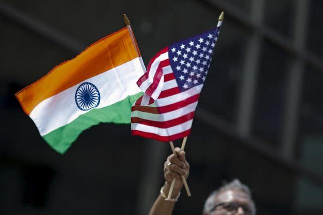 a man holds the flags of india and the u s while people take part in the 35th india day parade in new york august 16 2015 photo reuters