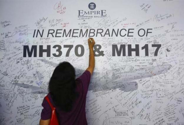 a woman writes a message on a dedication board for the victims of the downed malaysia airlines flight mh17 airliner and the missing flight mh370 in subang jaya outside kuala lumpur july 23 2014 reuters a woman writes a message on a dedication board for the victims of the downed malaysia airlines flight mh17 airliner and the missing flight mh370 in subang jaya outside kuala lumpur july 23 2014 reuters