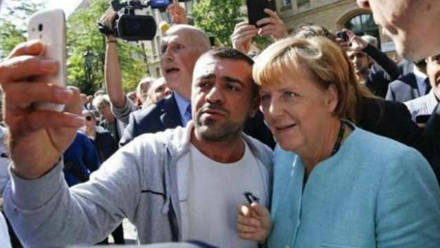 a migrant takes a selfie with angela merkel outside a refugee camp in berlin reuters a migrant takes a selfie with angela merkel outside a refugee camp in berlin reuters