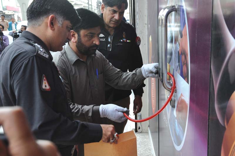 police officials open the locks outside the branch which was sealed after the robbery photo zafar aslam express