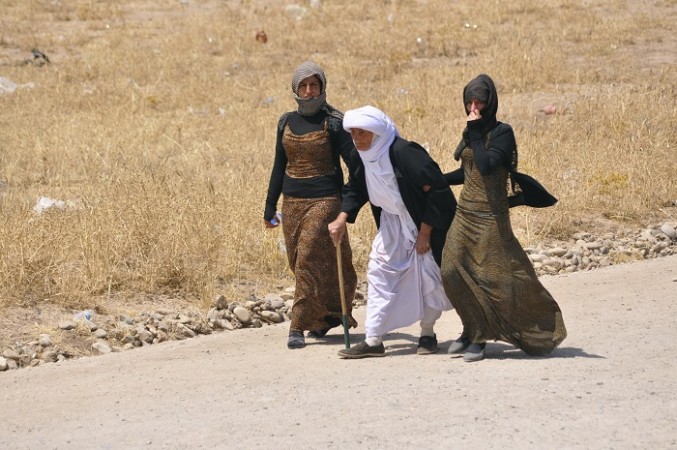 displaced families from the minority yazidi sect fleeing the violence walk on the outskirts of sinjar west of mosul 5 august photo reuters