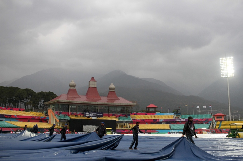 groundstaff cover the wicket as rain falls ahead of the world t20 match between oman and the netherlands at the himachal pradesh cricket association stadium in dharamsala on march 11 2016 photo afp