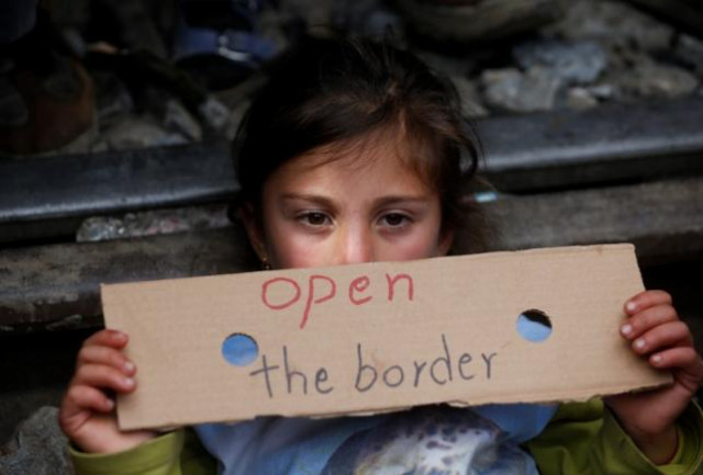 a migrant girl holds a poster as she blocks the railway track at the greek macedonian border near the village of idomeni greece march 12 2016 photo reuters a migrant girl holds a poster as she blocks the railway track at the greek macedonian border near the village of idomeni greece march 12 2016 photo reuters