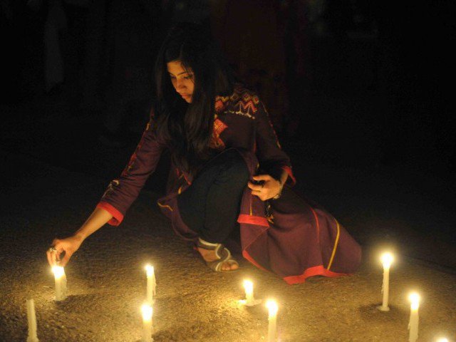 a pakistani girl lights candles in front of parliament house to mark the sixth global earth hour in islamabad on march 31 2012 photo afp