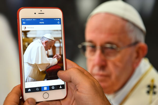 a man looks at the instagram account of pope francis franciscus launched today on march 19 2016 photo afp