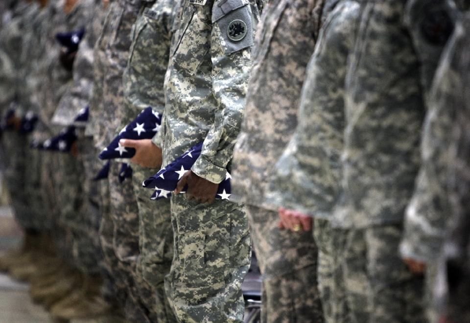 us soldiers hold a folded stars and stripes as they attend a naturalisation ceremony at al faw palace in baghdad 039 s camp victory on november 11 2010 photo afp