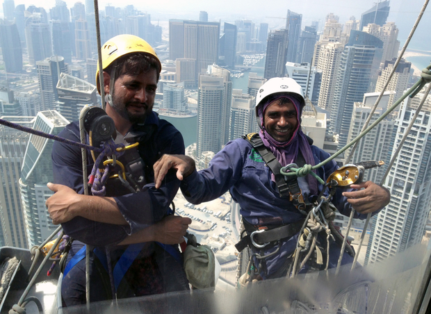 pakistani window cleaners work on a building in the gulf emirate of dubai on 6 september 2014 photo afp