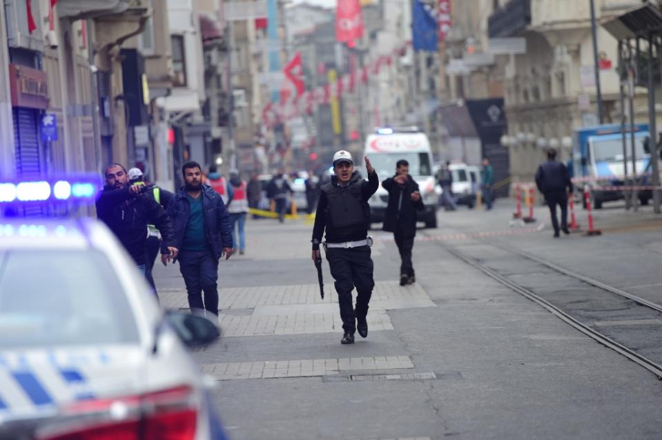 turkish police push people away just after an explosion on the pedestrian istiklal avenue in istanbul on march 19 2016 photo afp