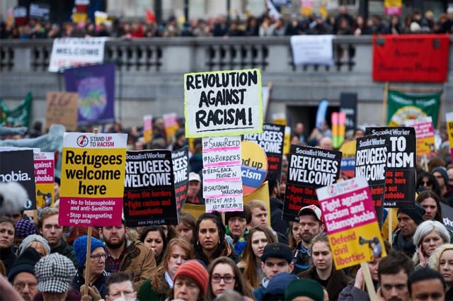 demonstrators hold banners in support of refugees as they march through central london on march 19 2016 photo afp