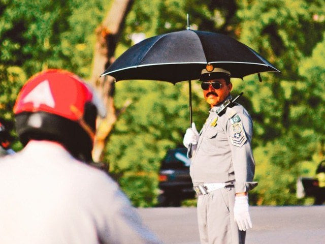 an islamabad traffic police official stands as a motorcycle passes through photo muhammad javaid an islamabad traffic police official stands as a motorcycle passes through photo muhammad javaid