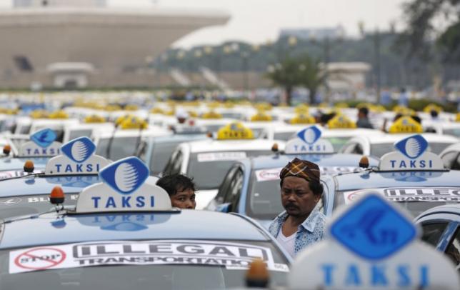 taxis are seen parked near the national monument as their drivers take part in a protest against what they say is unfair competition from ride hailing services in jakarta indonesia march 14 2016 photo reuters