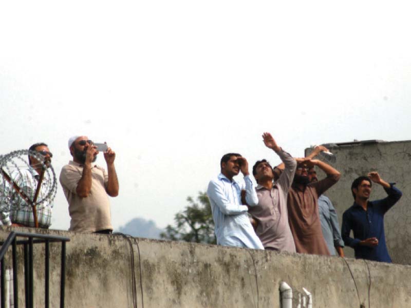 residents of rawalpindi trying to catch a glimpse of aircraft flying overhead photo waseem nazir express