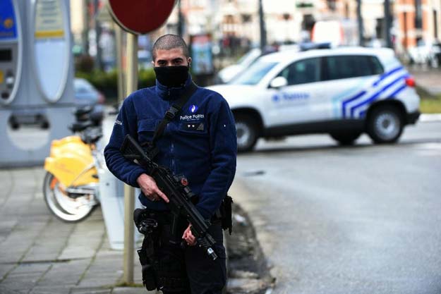 a belgian police officer stands guard during an anti terror raid in the schaerbeek   schaarbeek district of brussels on march 25 2016 photo afp