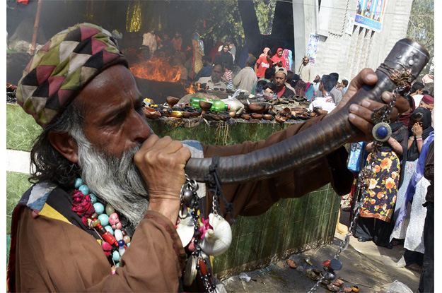 a malang playing a traditional instrument during mela charaghan at the shrine of hazrat madhu lal hussain photo online
