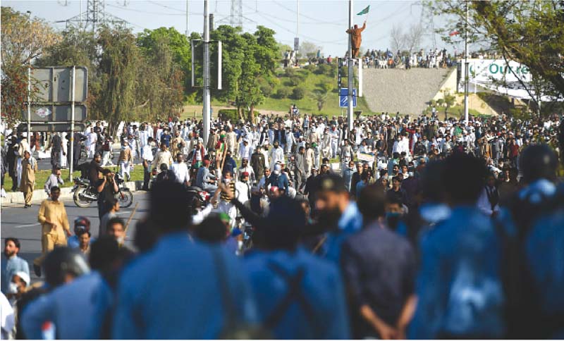 police officials run from protesters as they move towards the parliament at the islamabad highway photos afp