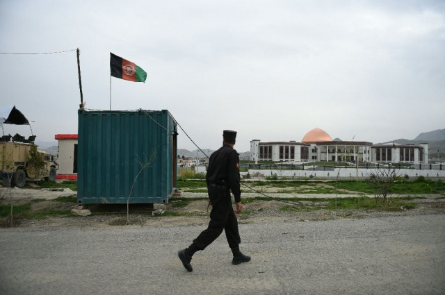 an afghan policeman walks in front of the newly built parliament complex in kabul on march 28 2016 after taliban insurgents fired a barrage of rockets at the complex photo afp