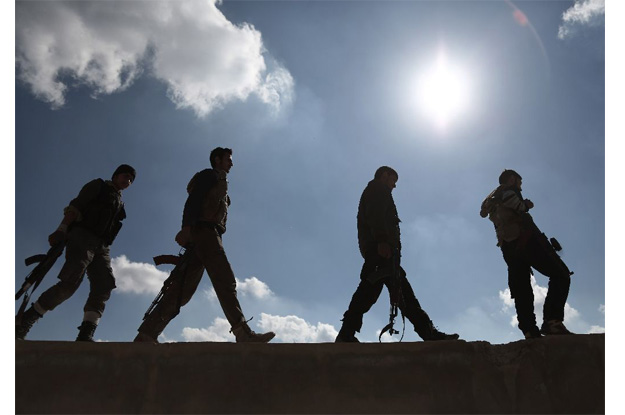 rebel fighters walk in tal al aswan in the area of the eastern ghouta rebel bastion east of the syrian capital damascus during clashes with government forces on february 9 2016 photo afp