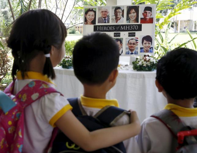 school children look at a board showing some of the passengers aboard the missing malaysia airlines flight mh370 on the second anniversary of its disappearance in kuala lumpur malaysia march 8 2016 photo reuters
