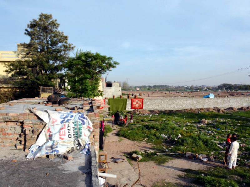 a view of the boundary wall of the under construction shahbaz sharif park in the distance that has blocked residents access to their homes in dhoke kaku shah rawalpindi photo express