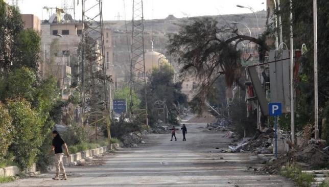 people walk along a damaged street in deir al zor eastern syria april 3 photo reuters