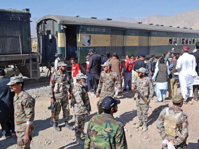 security officials stand next to a compartment of the train hit by an ied blast in mastung photo afp