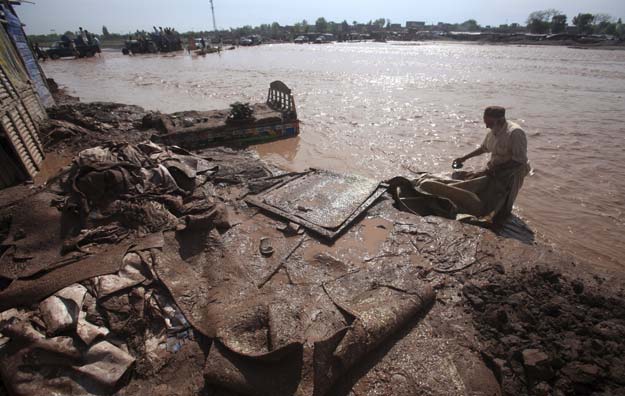 a man salvages his belongings from floodwaters in the sarband area on the outskirts of peshawar pakistan april 6 2016 photo reuters